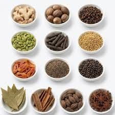 Bowls of Indian whole spices including cardamom, cloves, cinnamon and star anise